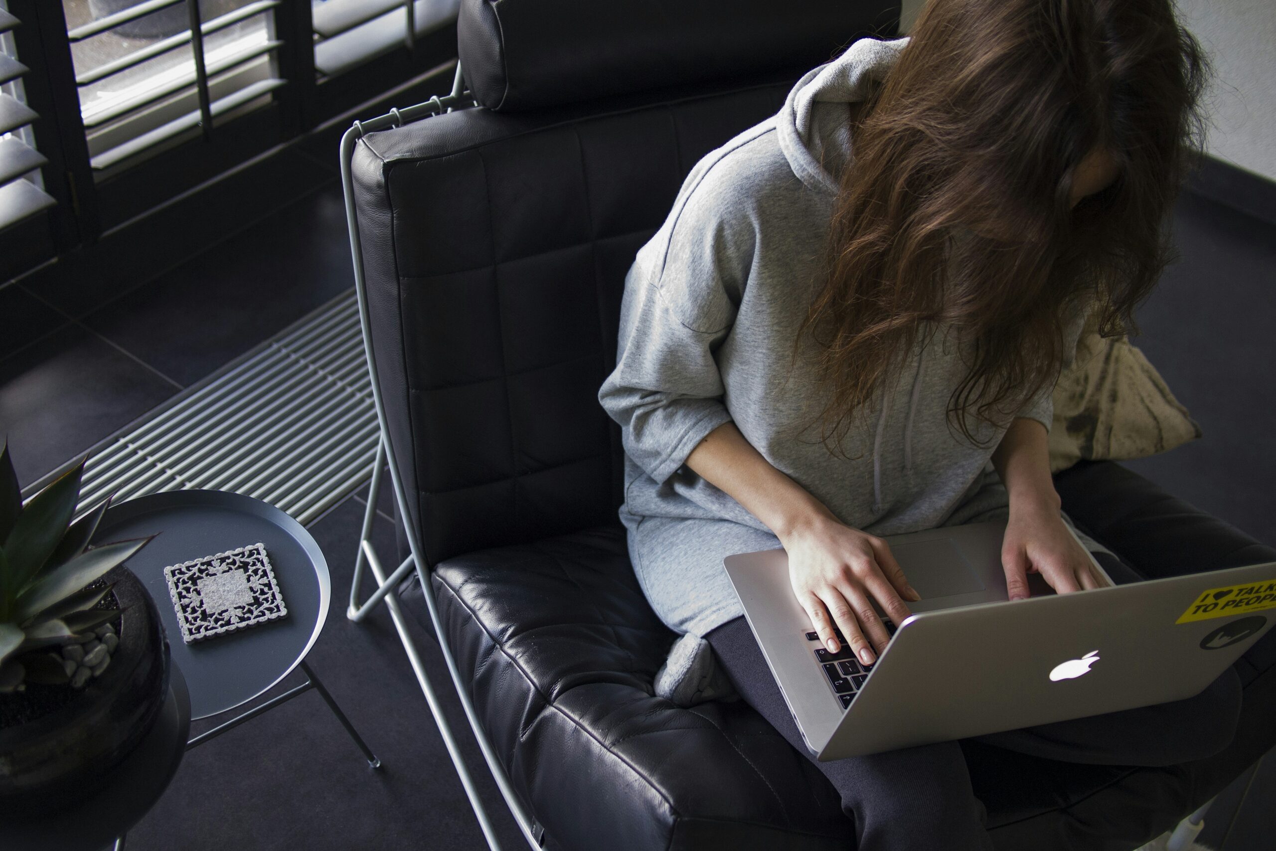 Frau arbeitet remote im Homeoffice an einem modernen Arbeitsplatz mit Laptop