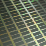 Macroaufnahme eines Silizium-Wafers mit einzelnen Chips und mikroskopischen Transistoren