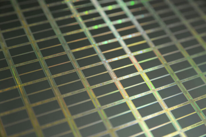 Macroaufnahme eines Silizium-Wafers mit einzelnen Chips und mikroskopischen Transistoren